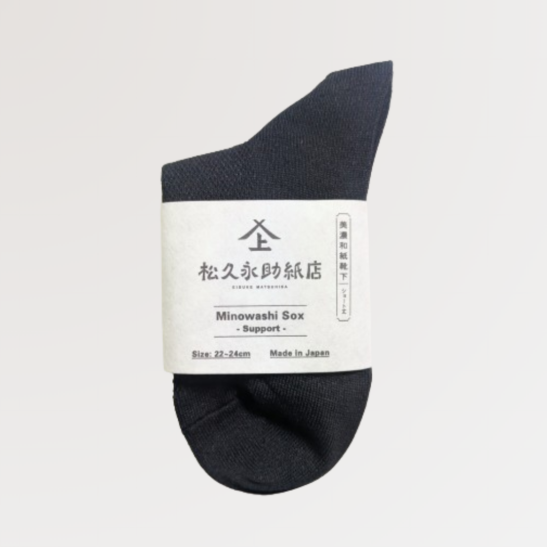 美濃和紙靴下、サポートシリーズのショート丈、22-24cm、黒色が1足うつっています。店名、商品名、サイズ、日本製である旨が記載された商品帯が商品の真ん中にまかれています。下記は関連するキーワードになります。美濃和紙靴下 サポートシリーズ ショート丈 22-24cm カラー展開 黒 ブラック サポート編み 歩きやすい 足の甲 フィット フィット感 ムレない 臭くなりづらい シャリ感 毛玉ができない 長く使える リピーターさん多数 吸湿性 消臭効果 抗菌効果 旅行 スポーツ ウォーキング メイドインジャパン 良いものを長く 丁寧な暮らし 環境に優しい 人に優しい エコフレンドリー サステナブル SDGs 産地から 紙糸 和紙糸 松久永助紙店オリジナル プレゼント 贈り物 ギフト 感謝 父の日 母の日 ちょっといいもの 和紙 和紙問屋 和紙卸 美濃和紙 美濃 岐阜 うだつの上がる町並み 老舗 和 松久永助紙店 オンラインショップ
