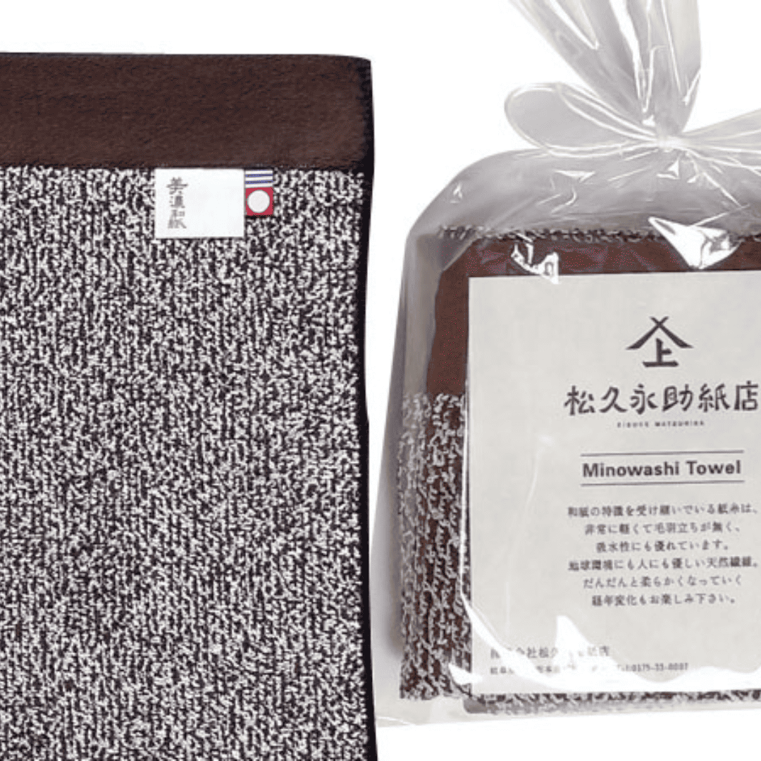 美濃和紙タオル、ソリッドの茶色、包装された状態(右)と広げられた状態のアップ(左)がうつっています。包装されている方は、正方形に小さく畳まれ、店名、商品名、商品説明が記載された紙(畳んだタオルと同じくらいの大きさ)とともに、透明の袋でに入れられています。袋の口は紙糸をリボン結びにして縛られています。広げられた方には2種類のタグが付いている様子も見えます。タグは「美濃和紙」とかかれたもの(右側)と、今治タオルのブランドロゴ(左側)です。下記は関連するキーワードになります。無地 使いやすい 気を使わせない お返し プレゼント 機能的 軽い 乾きやすい 母の日 父の日 ギフト おすすめ 日本製 和紙タオル 紙糸 生地 松久永助紙店 オンラインショップ