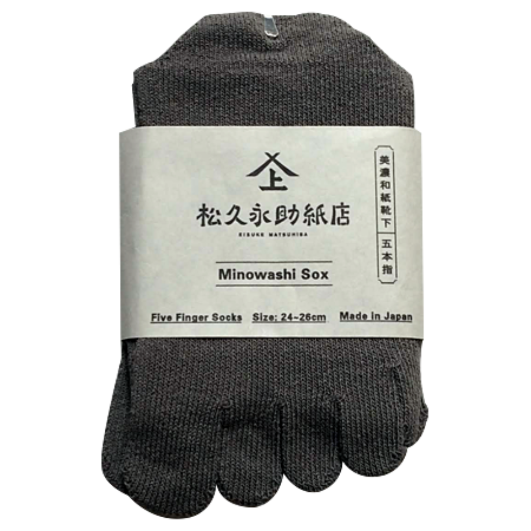 美濃和紙靴下の5本指タイプが1足うつっています。色は濃いグレーです。サイズは24-26cmです。商品の真ん中には商品帯がまかれています。商品帯には店名、商品名、サイズ、日本製である旨が記載されています。下記は関連するキーワードになります。美濃和紙靴下 5本指 ムレない 臭くなりづらい シャリ感 毛玉ができない 長く使える リピート 吸湿性 消臭効果 抗菌効果 旅行 ウォーキング 健康 メイドインジャパン 良いものを長く 丁寧な暮らし 環境に優しい 人に優しい エコフレンドリー サステナブル SDGs 産地から 紙糸 和紙糸 松久永助紙店オリジナル プレゼント 贈り物 ギフト 感謝 父の日 母の日 ちょっといいもの 和紙 美濃和紙 松久永助紙店 オンラインショップ
