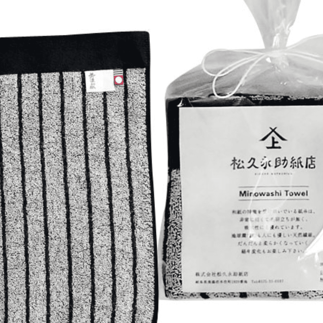 美濃和紙タオル、ストライプ柄の黒、包装された状態(右)と広げられた状態のアップ(左)がうつっています。包装されている方は、正方形に小さく畳まれ、店名、商品名、商品説明が記載された紙(畳んだタオルと同じくらいの大きさ)とともに、透明の袋でに入れられています。袋の口は紙糸をリボン結びにして縛られています。広げられた方には2種類のタグが付いている様子も見えます。タグは「美濃和紙」とかかれたもの(右側)と、今治タオルのブランドロゴ(左側)です。下記は関連するキーワードになります。ハンドタオル 和紙タオル 美濃和紙タオル 美濃和紙 紙糸 自然素材 環境に優しい 日本製 おすすめ 人気 プレゼント 松久永助紙店 オンラインショップ