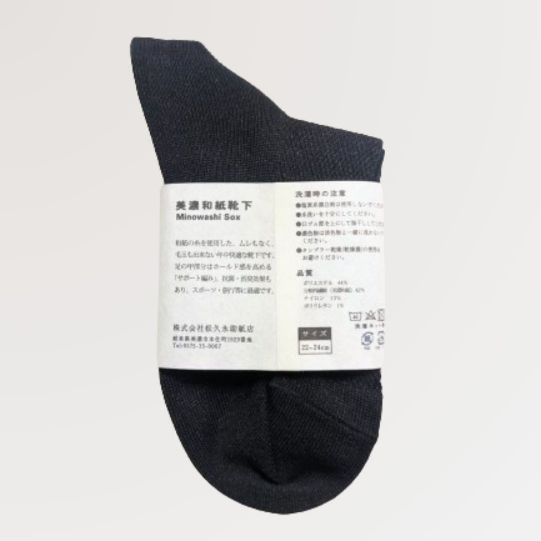 美濃和紙靴下、サポートシリーズのショート丈、22-24cm、黒色が1足うつっています。商品の真ん中に商品帯がまかれており、後ろ側が見えるように置かれています。商品帯には美濃和紙靴下の説明、サイズ、店名、品質、洗濯時の注意が記載されています。下記は関連するキーワードになります。美濃和紙靴下 サポートシリーズ ショート丈 サイズ展開 22-24cm 25-27cm サポート編み 歩きやすい フィット感 ムレない 臭くなりづらい シャリ感 毛玉ができない 長く使える リピーターさん多数 おすすめ 消臭効果 抗菌効果 旅行 スポーツ ウォーキング メイドインジャパン 良いものを長く 丁寧な暮らし 環境に優しい 人に優しい エコフレンドリー サステナブル SDGs 産地から 紙糸 和紙糸 松久永助紙店オリジナル プレゼント 贈り物 ギフト 感謝 父の日 母の日 ちょっといいもの 和紙 和紙問屋 和紙卸 美濃和紙 美濃 岐阜 老舗 松久永助紙店 オンラインショップ 近くで和紙が売ってるところ