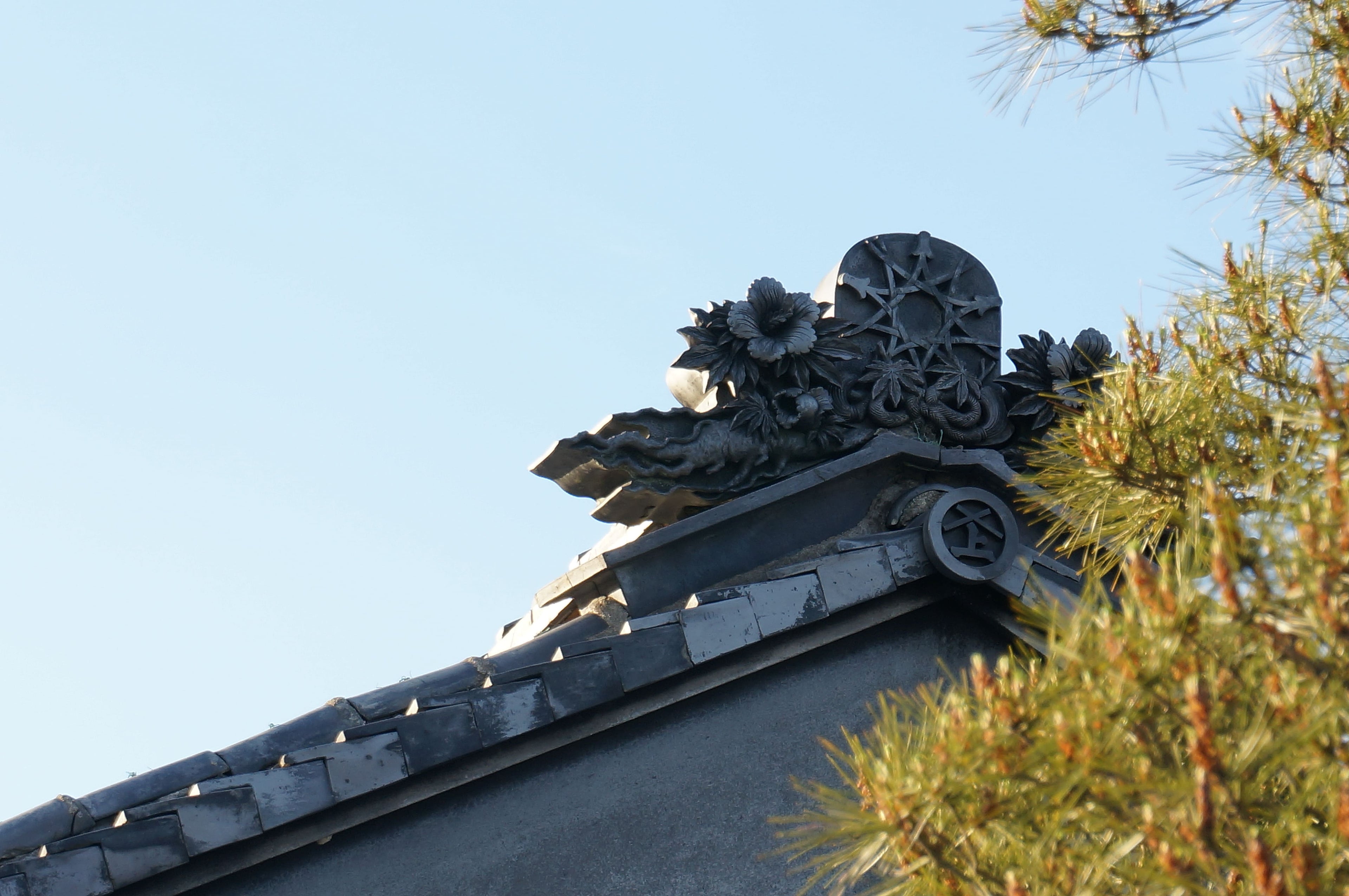 松久永助紙店の創業者である二代目永助が大切にした「星松葉」モチーフの鬼瓦が、松の葉と共にうつされた写真です。このモチーフは5つの松葉を星のように組み合わせたものです。■松久永助紙店では紙糸(和紙糸)、紙布(和紙布)、美濃和紙靴下(和紙ソックス)、美濃和紙タオルなどの美濃和紙をつかった生活雑貨などを取り扱っています。主な商品は、和紙・美濃和紙(楮紙/こうぞ紙・マニラ麻・落水紙・本美濃紙/那須楮・墨流し)、和紙雑貨(カードケース・さついれ・干支カレンダー)、和紙文具(ノート・マスキングテープ・和紙はがき)、紙布雑貨(手ぬぐい・ワインバッグ・トートバッグ・ポーチ・ランチョンマット・マルチクロス)、生活雑貨(アクセサリー・ハンカチ・ハンドタオル・フェイスタオル・バスタオル・サウナタオル/ロングタオル・靴下/ソックス・アームカバー・信玄袋)、和紙布(帆布・ガーゼ・シャツ地・ニット・天竺・ヘリンボーン・手ぬぐい・コットン混・リネン混)、和紙糸(Kamito糸柱・ネロ・編み物用・織物用・刺繍用・玉売り・綛売り・コーン売り)です。