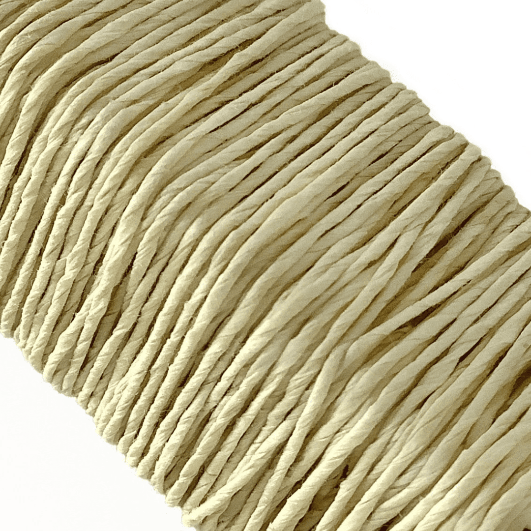 白い背景に、Kamito糸柱の黄（キハダ）がうつっています。糸や色の風合いがわかるようアップで撮影された写真です。原料内訳は美濃和紙100％です。下記は関連するキーワードになります。紙糸 和紙糸 草木染め オリジナル 機械漉き 美濃和紙 自然素材 天然繊維 エコ サスティナブル 環境に優しい 人に優しい ハンドメイド クラフト 材料 素材 ラッピング アクセサリー作り 小物づくり タッセル ニット 編み物 刺繍 黄色 キハダ染め 販売 松久永助紙店 オンラインショップ