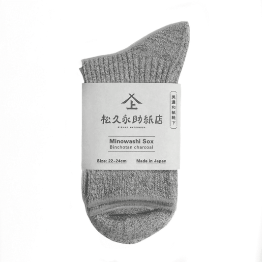 美濃和紙靴下、ベーシックタイプ、22-24cm、グレー（備長炭）が1足、半分に折りたたまれた状態でうつっています。店名、商品名、サイズ、日本製である旨が記載された商品帯が商品の真ん中にまかれています。下記は関連するキーワードになります。靴下 ソックス 和紙製品 美濃和紙 こだわり 機能的 おすすめ ムレない 消臭 抗菌 健康対策 エコ プレゼント 母の日 父の日 敬老の日 おすすめ 人気 松久永助紙店 オンラインショップ