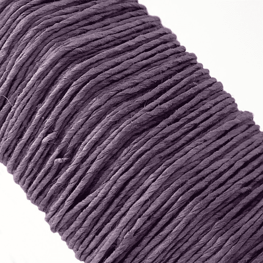 白い背景に、Kamito糸柱の紫（ログウッド）がうつっています。糸や色の風合いがわかるようアップで撮影された写真です。原料内訳は美濃和紙100％です。下記は関連するキーワードになります。紙糸 和紙糸 草木染め オリジナル 機械漉き 美濃和紙 自然素材 天然繊維 エコ サスティナブル 環境に優しい 人に優しい ハンドメイド クラフト 材料 素材 ラッピング アクセサリー作り 小物づくり タッセル ニット 編み物 刺繍 紫色 ラベンダーカラー くすみカラー 販売 松久永助紙店 オンラインショップ