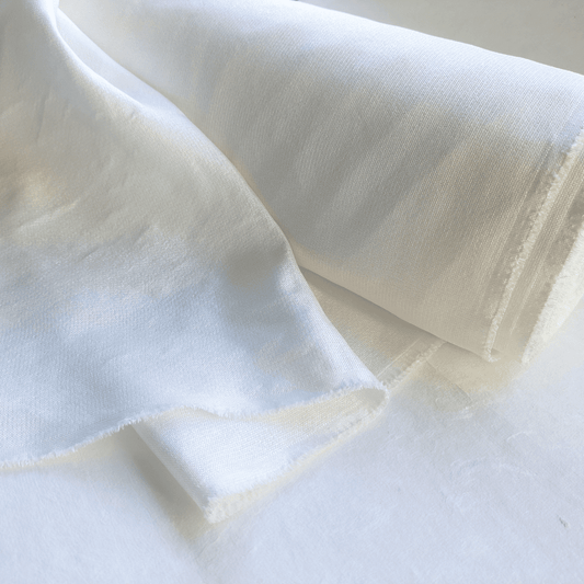白い背景に、美濃和紙と銀イオン配合ポリエステルでできたトリプルガーゼがうつっています。ロール状にまかれた生地から、質感がわかるよう少し引き出された状態です。色は生成り色です。下記は関連するキーワードになります。美濃和紙 ポリエステル 銀イオン配合 トリプルガーゼ ガーゼ生地 マスク ハンドメイド 縫製 服 小物 インテリア 紙布 和紙布 和紙生地 服 紙糸 和紙糸 松久永助紙店オリジナル テキスタイル textile 布 生地 素材 材料 販売 企画 開発 近くで和紙が売ってるところ 松久永助紙店 オンラインショップ